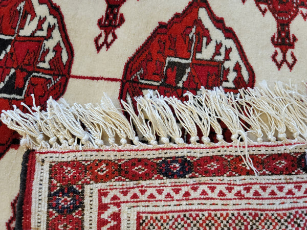 close up fine quality handmade wool pile on silk turkmen rug red ivory beige